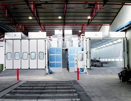 Pressurized oven booths on metal basement with dry filtering system and upper openings for inserting pieces with overhead crane