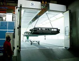 Cabina forno pressurizzata su basamento metallico con sistema filtrante a secco e apertura superiore per inserimento pezzi con carroponte