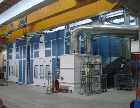 Pressurized oven booths with wet filtering system and upper openings for inserting pieces with overhead crane