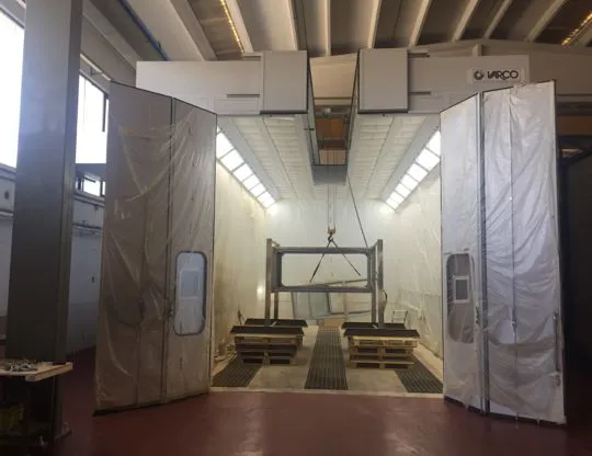 Pressurized oven booth with upper opening for inserting containers with overhead crane