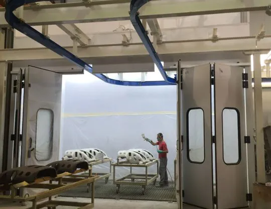 Pressurized oven booth with total front opening and rails for hangers entry