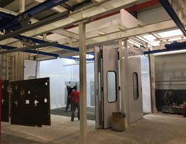 Pressurized oven booth with total front opening and rails for hangers entry