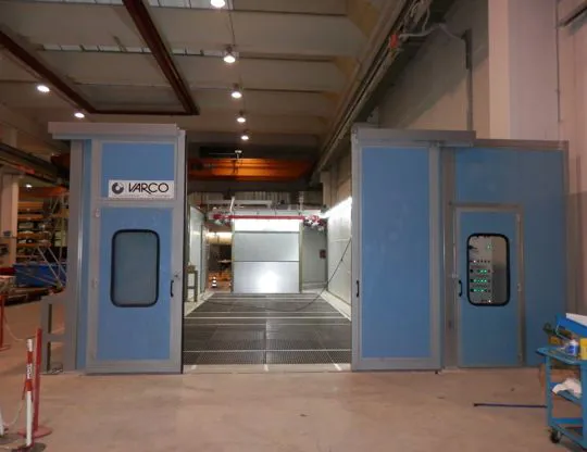Grid floor with wet filtering system, front water curtain booth and perimeter paneling with sliding doors