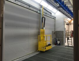 Internal view of pressurized spray booth with vertical air ventilation with three-axis mobile platforms for operators